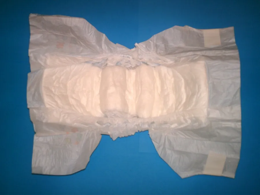 Unfolded disposable diaper on a blue background