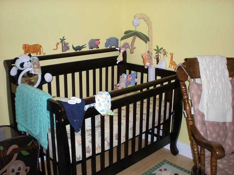 Dark wood crib with a mobile and blankets